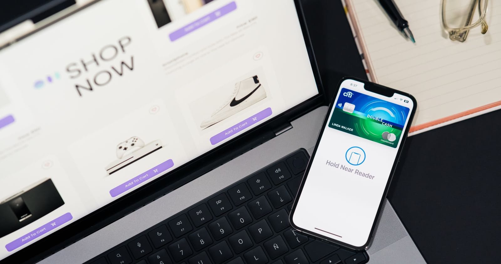 An ecommerce storefront open on a laptop beside a smartphone with a digital wallet ready to pay at checkout